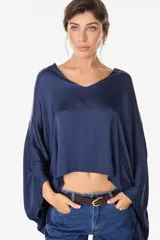 Blusa de algodón azul marino con escote en V, mangas murciélago amplias y diseño corto de corte asimétrico.