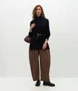 Suéter de punto de corte oversize y largo alargado, con cuello alto, mangas largas y aberturas laterales sutiles. Presenta puños y ruedo con acabado acanalado.