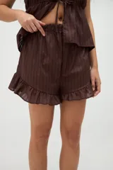 Short de pijama de algodón color marrón con diseño de rayas sutiles, cintura elástica y detalle de volados en el ruedo.