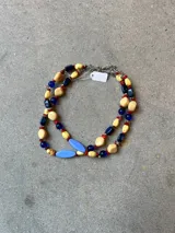 Collar doble de abalorios multicolor con cuentas de acrílico en tonos beige, azul, rojo y celeste, intercaladas con piedras y cristales. Cuenta con cadena y cierre de acero.