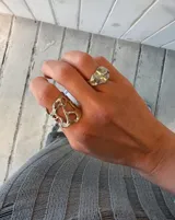 Anillo ancho de diseño orgánico y calado, con apariencia de red o magma solidificado.