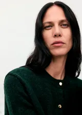 Cardigan de punto de corte recto, con cuello redondo, manga larga y cierre frontal mediante botones metálicos.