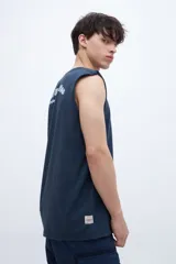 Musculosa azul marino con cuello redondo y sisas amplias. Presenta un pequeño estampado en el pecho con texto en blanco.