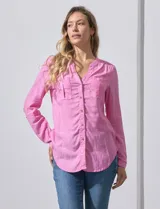 Blusa rosa de lino marca Zac & Rachel, con cuello a la base, escote en V y abertura central con botones. Tiene bolsillos delanteros y mangas largas regulables con presilla y botón.