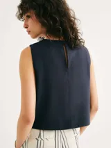 Blusa sin mangas de corte recto y holgado, con cuello redondo y diseño minimalista en color verde.
