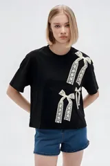 Remera oversize de algodón color gris oscuro, con cuello redondo, mangas cortas y estampado lateral en tonos claros de cadenas y una llave.