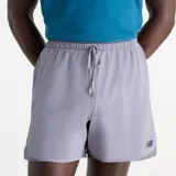 Short de running New Balance RC Essential de color gris, con cintura elástica y cordón ajustable, aberturas laterales y logo de la marca en la pierna izquierda.