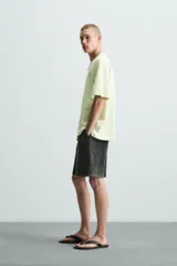 Camiseta de corte relaxed fit, color verde lima pálido, con cuello redondo y manga corta. Presenta un estampado sutil en el pecho.