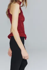 Corset bordó de cuello halter con hombros descubiertos, confeccionado con combinación de tejidos con patrón floral, detalles de volados en las sisas y bajo en peplum. Cuenta con cierre en la espalda con cremallera.