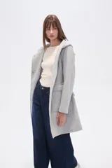 Tapado negro de manga larga con capucha, bolsillos frontales tipo parche y lazo ajustable en la cintura.