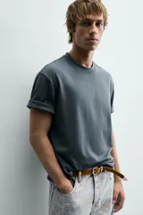 Camiseta de corte relajado confeccionada en tejido interlock de algodón con elasticidad, presenta cuello redondo y manga corta.