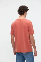 Remera de algodón lavado con textura suave, de manga corta y calce relaxed, color salmón con diseño estampado y bordado en el pecho.