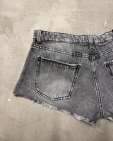 Short de jean gris con efecto lavado, tiro alto y ruedo desflecado.