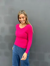 Sweater de punto acanalado color fucsia, con escote en V y mangas largas con puños lisos. Diseño entallado y tejido suave.