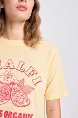 Remera amarilla de manga corta con estampa de limones y texto en color rojo.