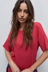Vestido midi negro de algodón con calce relajado, silueta recta, cuello redondo, mangas cortas amplias y tajos laterales.