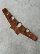 Cinturón de cuero marrón con tres argollas plateadas.