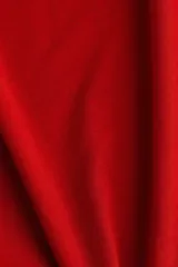 Top de punto color rojo con cuello alto y mangas largas. Presenta un diseño liso con terminaciones de borde sobrehilado en los puños y en el ruedo.
