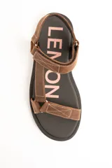 Sandalias planas de cuero marrón con tiras regulables mediante velcro y suela negra.