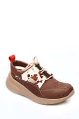 Zapato deportivo abierto en el talón, confeccionado en cuero liso marrón con detalles de cuero con pelo estampado tipo animal print en la parte superior. Presenta cierre con cordones, perforaciones decorativas en la puntera y una suela de plataforma color beige.