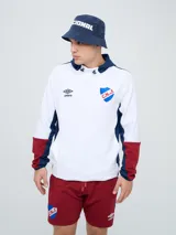 Canguro deportivo Umbro del Club Nacional de Football, modelo Evoque. Diseño con bloques de color blanco en el torso, azul en la capucha, laterales y parte superior de las mangas, y rojo en los puños. Incluye capucha con cordón ajustable, logo de Umbro y escudo del club bordados en el pecho.