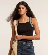 Musculosa negra de poliéster, viscosa y elastano, con escote cuadrado y tirantes anchos a rayas horizontales blancas y grises.