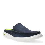 Zapato tipo mule de hombre con diseño de mocasín, confeccionado en cuero azul marino con costuras visibles. Presenta una suela blanca de goma con detalle en color verde neón en el talón.