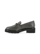Mocasín de cuero color verde militar con suela track negra y detalle de herraje metálico dorado en el empeine.