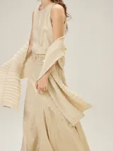 Chal de punto color beige con textura acanalada y sutil brillo metalizado.