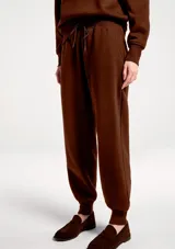 Pantalón deportivo tipo babucha color marrón, con cintura elástica ajustable mediante cordón y puños acanalados en los tobillos.
