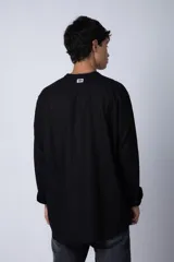 Camisa de lino color blanco con cuello mao y cierre frontal de botones. Presenta mangas largas con puños simples y un corte clásico.