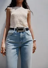 Pantalón de jean estilo flare con tiro medio, cierre de botón y cremallera, trabillas para cinturón y diseño de cinco bolsillos.