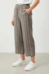 Pantalon de corte holgado y tiro medio, con diseño de rayas verticales en tonos marrones y grises. Presenta cintura elástica y bolsillos laterales.