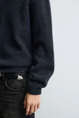 Jersey de punto con textura efecto pelo, corte boxy fit, cuello redondo y manga larga con acabados en rib.