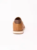 Zapatilla tipo slip-on color marrón, con diseño minimalista, elásticos laterales para mayor comodidad y suela blanca con detalle de costura visible.