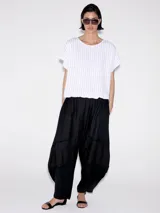 Pantalón babucha negro con paneles de diferente textura.