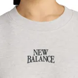 Buzo de cuello redondo New Balance, color gris melange, con corte cropped y mangas amplias. Presenta el logo de la marca bordado en el centro del pecho en color negro.