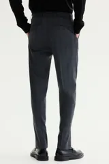 Pantalón de traje gris con sutil patrón a cuadros, corte slim fit con raya marcada en las piernas, bolsillos laterales y bolsillos traseros ribeteados.