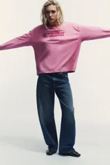 Camiseta de manga larga en color rosado con cuello redondo. Presenta un estampado frontal con la frase 'On Wednesday we wear pink' y el logo de Mean Girls en color fucsia.