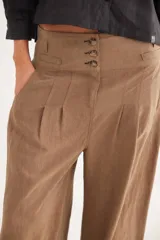 Pantalón de tiro alto en color azul, con cierre frontal de tres botones, pinzas en la cintura y corte holgado.