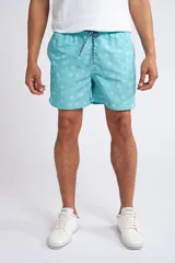 Short de baño con cintura elástica y cordón ajustable, confeccionado en tela ligera de secado rápido. Presenta un estampado botánico integral en tonos amarillos, blancos y azules, con dos bolsillos delanteros y uno posterior.