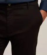 Pantalón de vestir negro de corte slim, confeccionado en tejido de sarga de algodón y elastano.