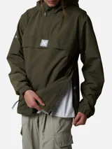 Canguro tipo anorak de color gris oscuro, con capucha ajustable, bolsillo frontal con solapa y cierre de media cremallera. Presenta detalles en color naranja en los tiradores de los cierres y un parche con el logo de la marca en el centro del pecho.