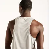 Musculosa deportiva New Balance modelo Sport Essentials, color gris, de corte clásico y tejido transpirable.