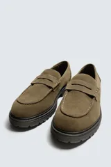 Mocasín de vestir para hombre, confeccionado en piel con acabado de serraje en color marrón oscuro. Presenta un diseño clásico con detalle de antifaz en el empeine, horma redonda y una suela track robusta de goma.