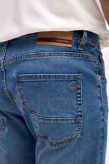 Jean de corte slim, con diseño de cinco bolsillos y cierre frontal con botón y cremallera.