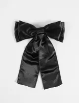 Broche para el pelo con forma de moña grande de tela estructurada color negro.