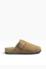 Zueco de gamuza marrón con hebilla metálica lateral ajustable, suela de corcho y base de goma negra.