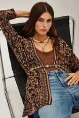 Saco de tejido de punto abierto, sin cuello ni cierre, con estampado tipo ikat o animal print en tonos marrón, negro y rosado pálido.