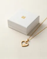 Dije de acero con baño de oro en forma de corazón calado con un pequeño corazón sólido en su interior.